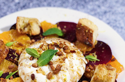 Salade à l’orange, betterave, burrata, pignons de pin et morceaux de pain dorés à l’huile d’olive.